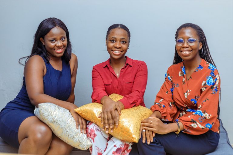Three smiling young women representing future leaders in cloud computing for women.